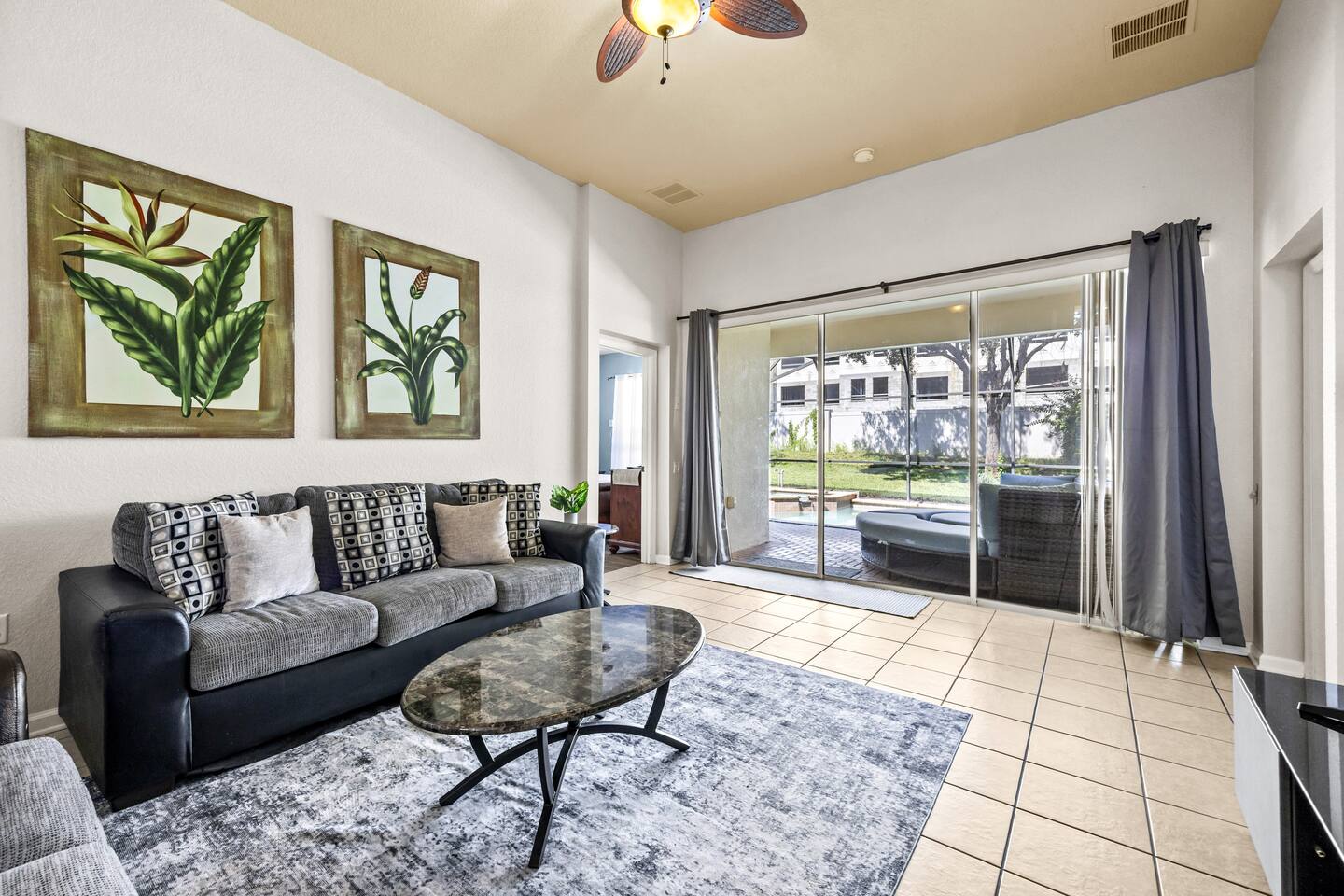 Living area with a sectional sofa, coffee table, and sliding doors to the pool l