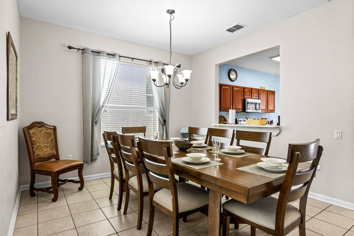 Dining area with a wood table set for eight and a pass-through to the kitchen.