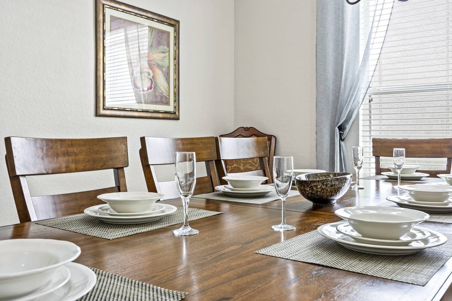Close-up of the dining table place settings with plates, bowls, and glassware.