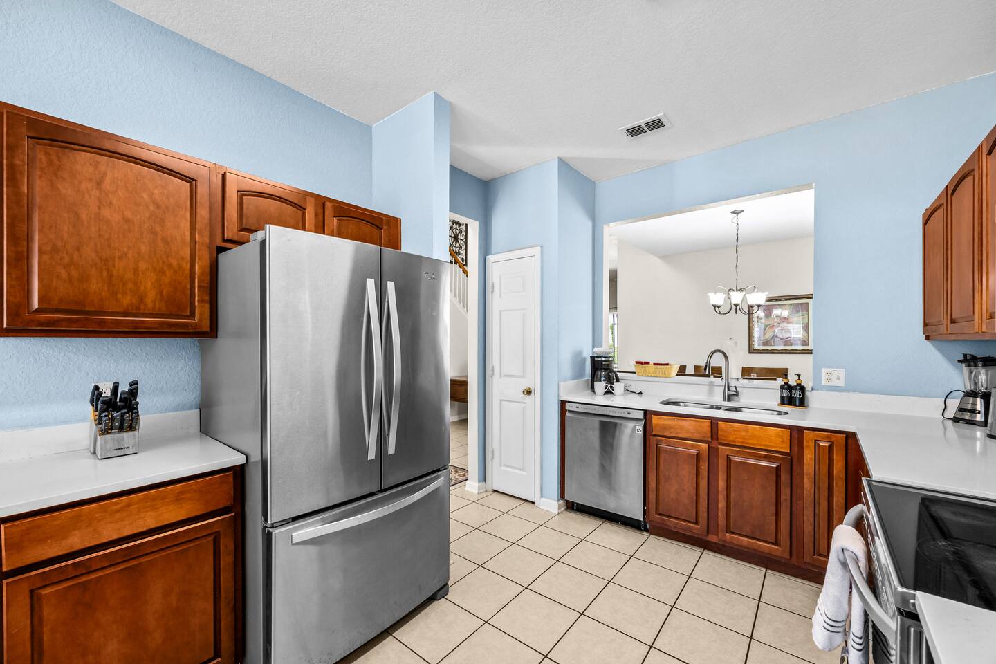 Kitchen with stainless steel appliances, wood cabinetry, and a breakfast-bar pas
