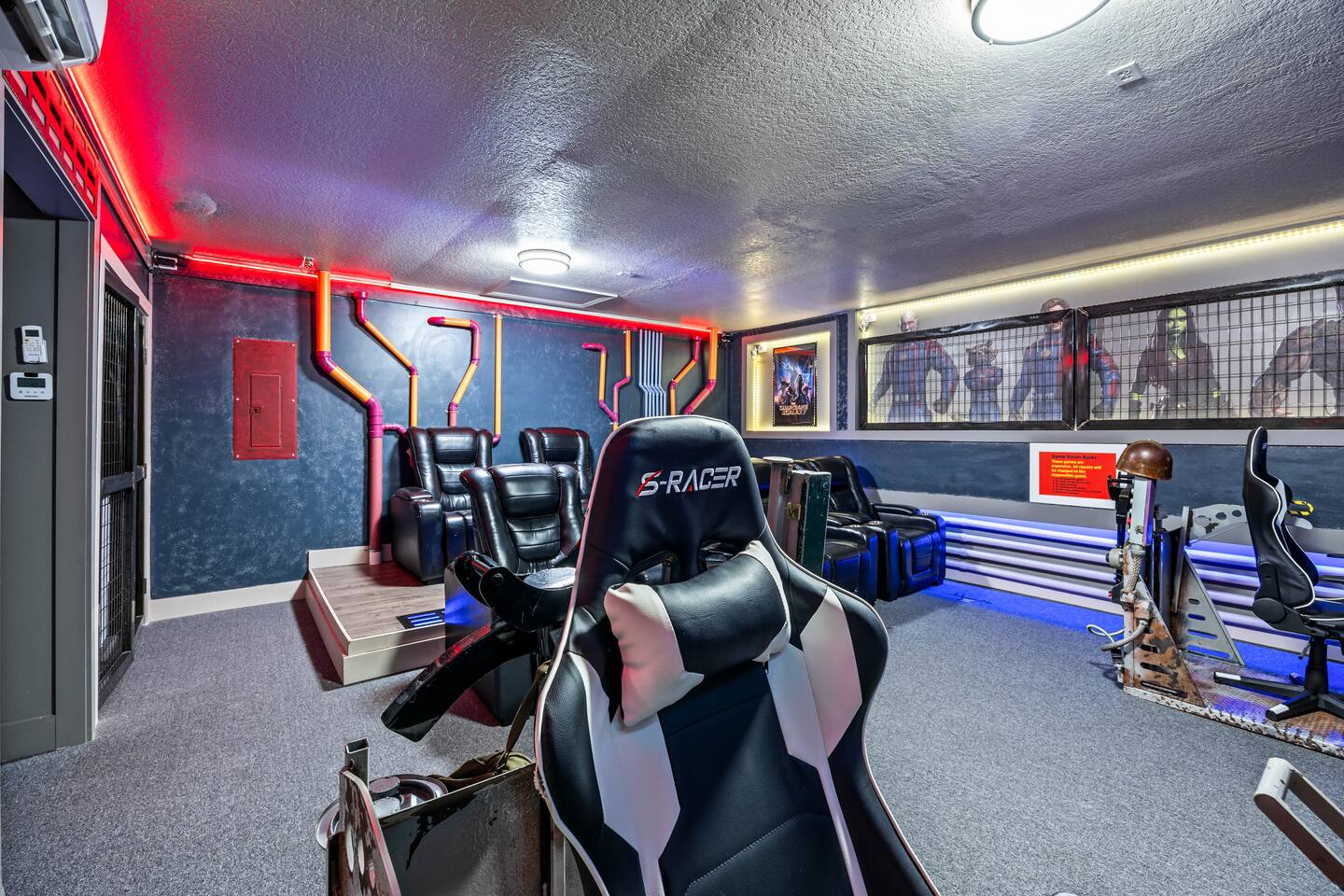 Game room and theater with a racing gaming chair, recliners, and Guardians of th