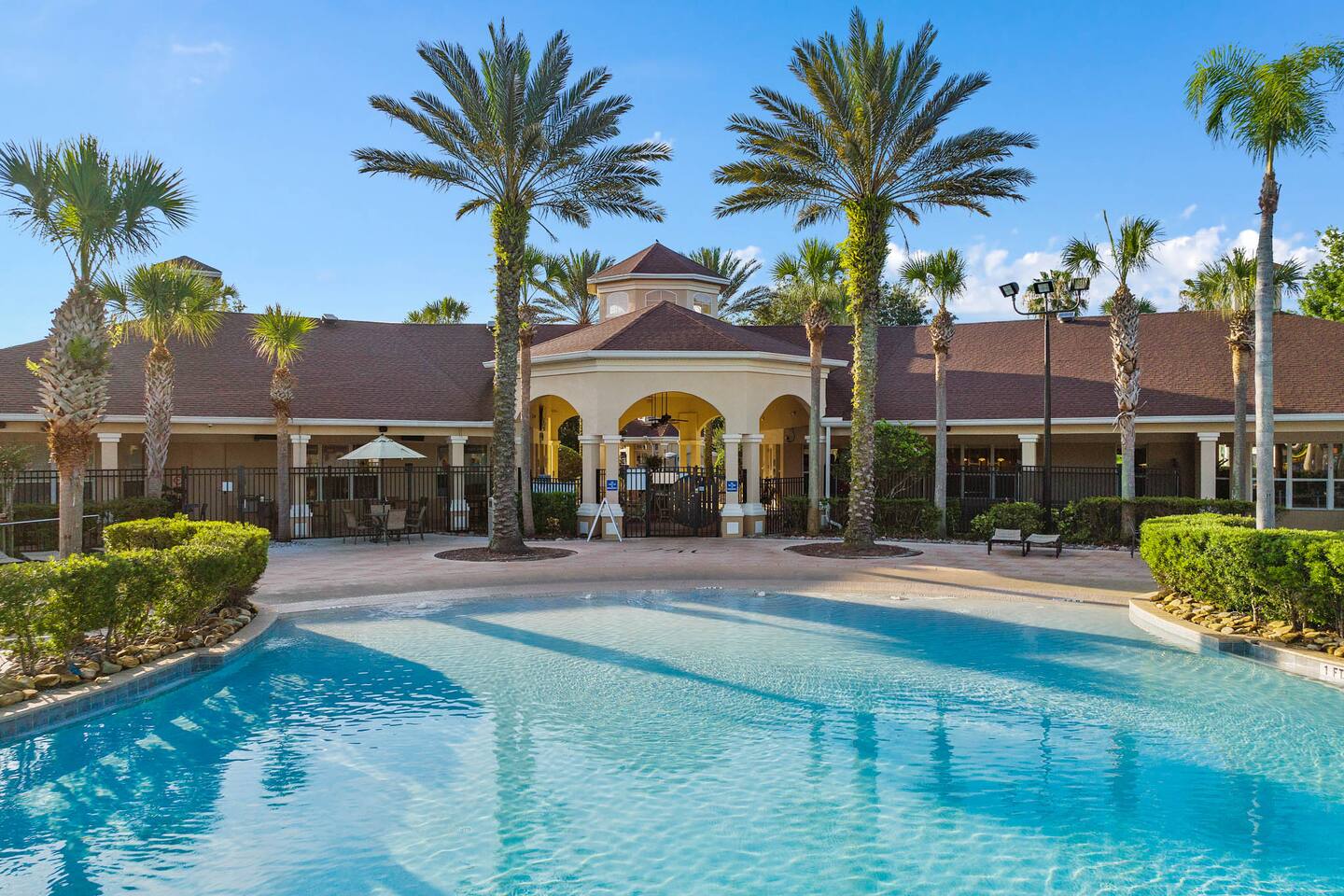Windsor Hills clubhouse exterior with palm trees and a resort-style pool.